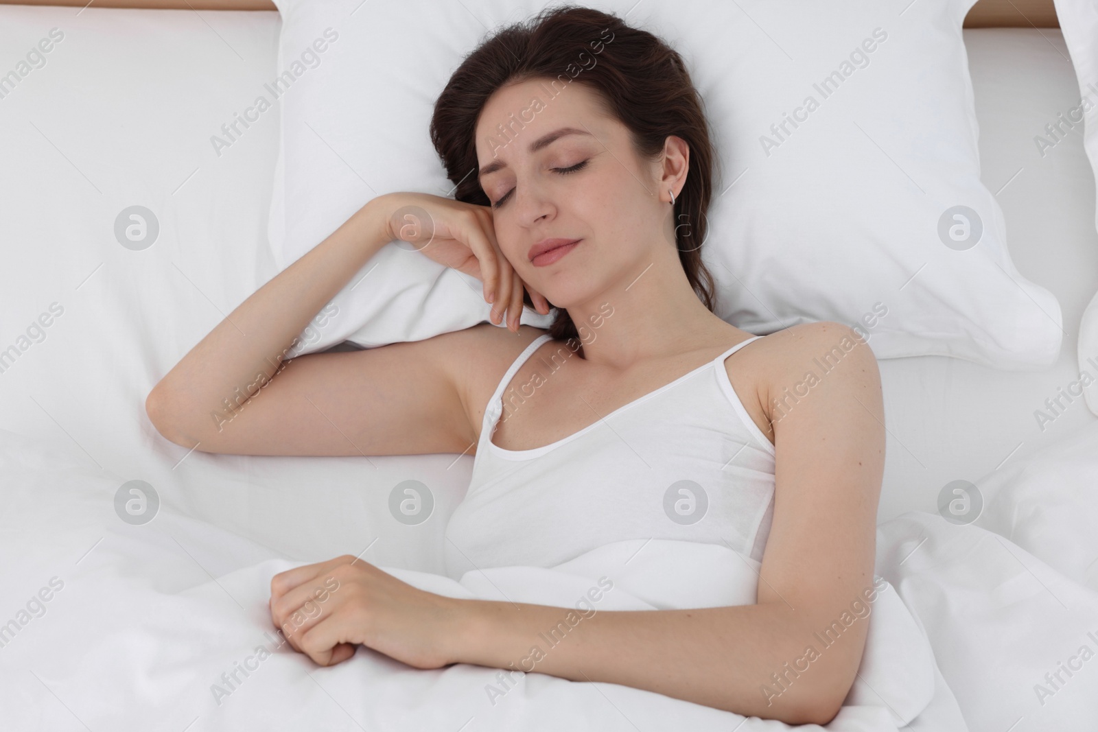 Photo of Bedtime. Woman sleeping in bed at home, above view