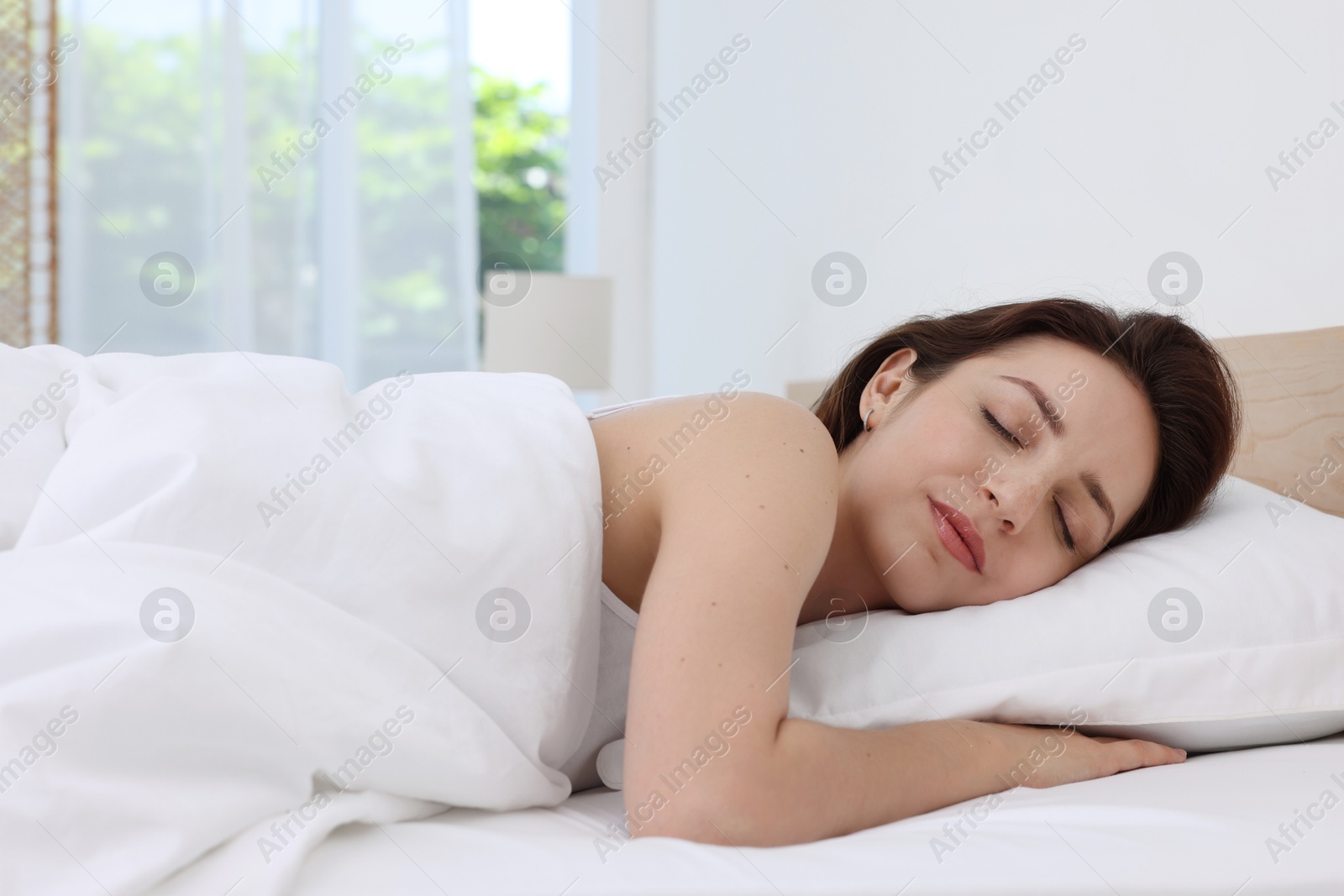 Photo of Bedtime. Woman sleeping in bed at home