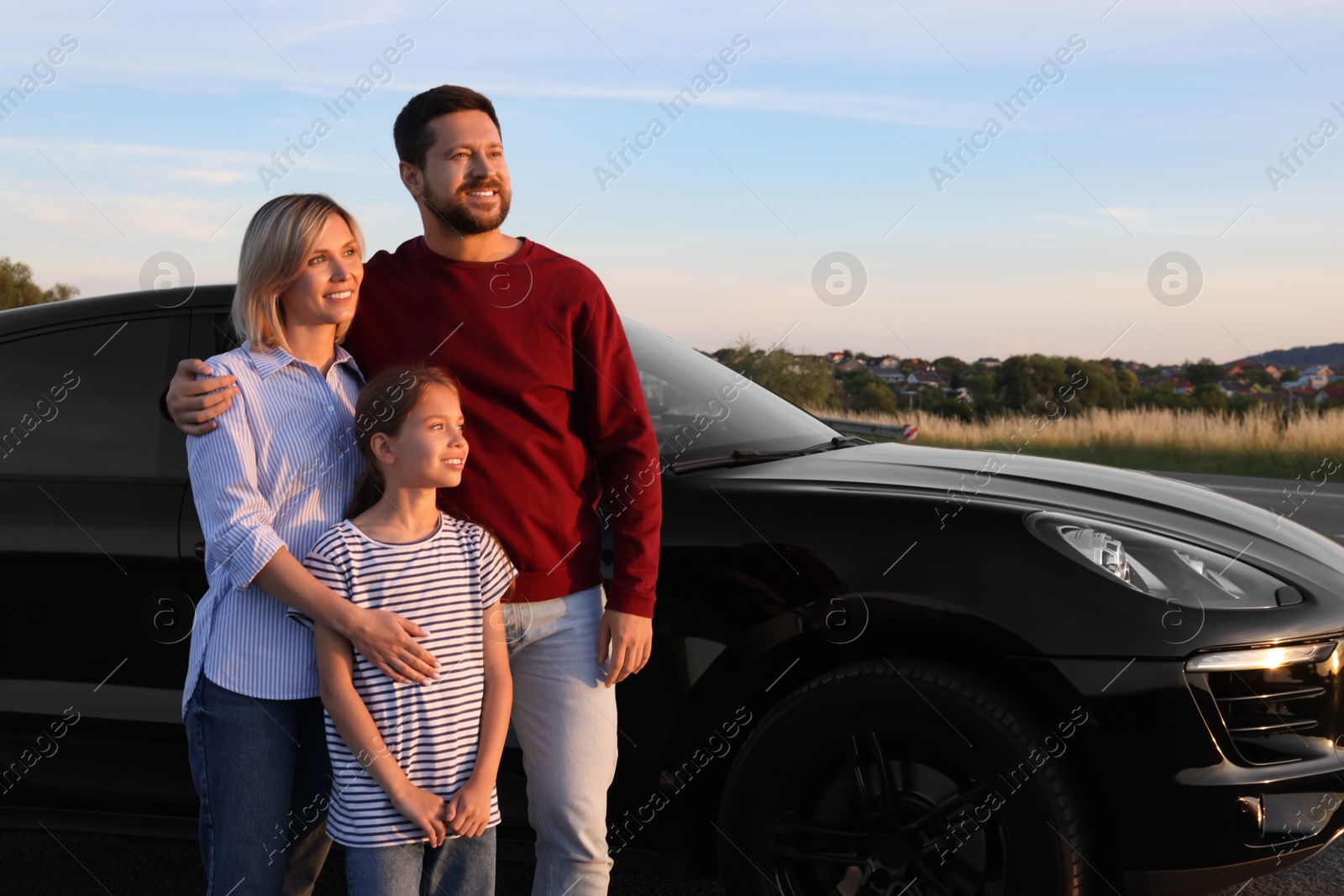 Photo of Happy parents and their daughter near car outdoors