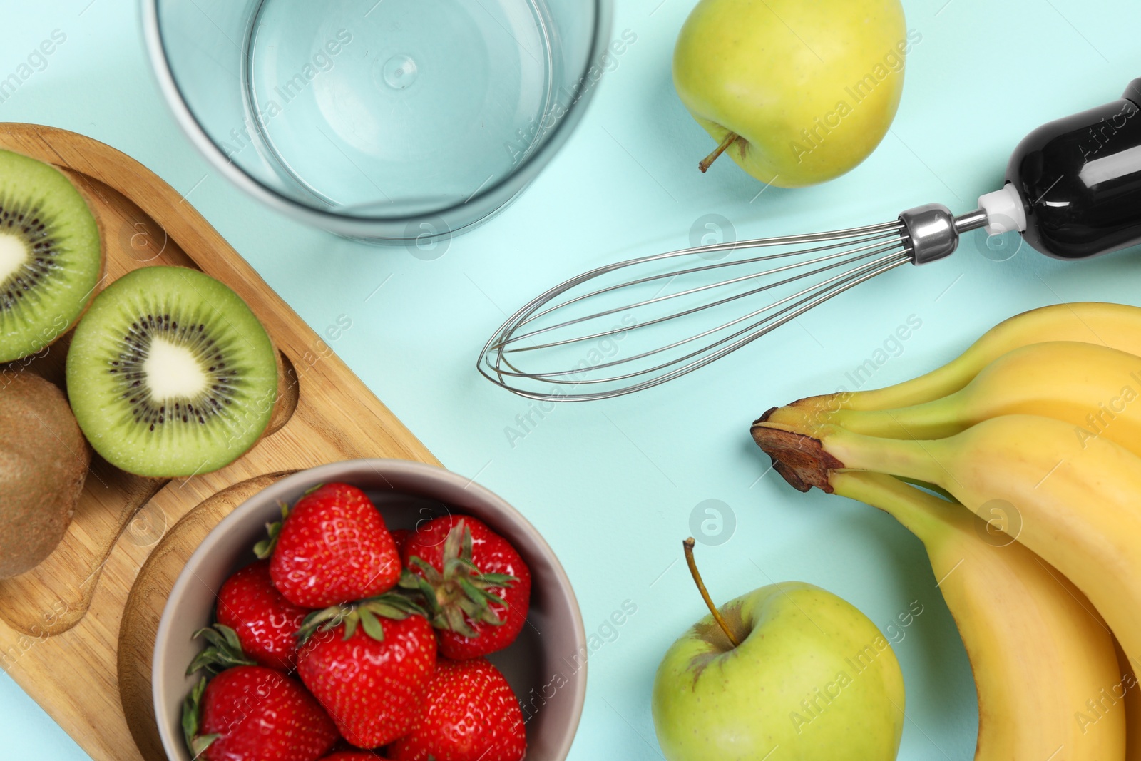 Photo of Hand blender kit and fresh fruits on light blue background, flat lay