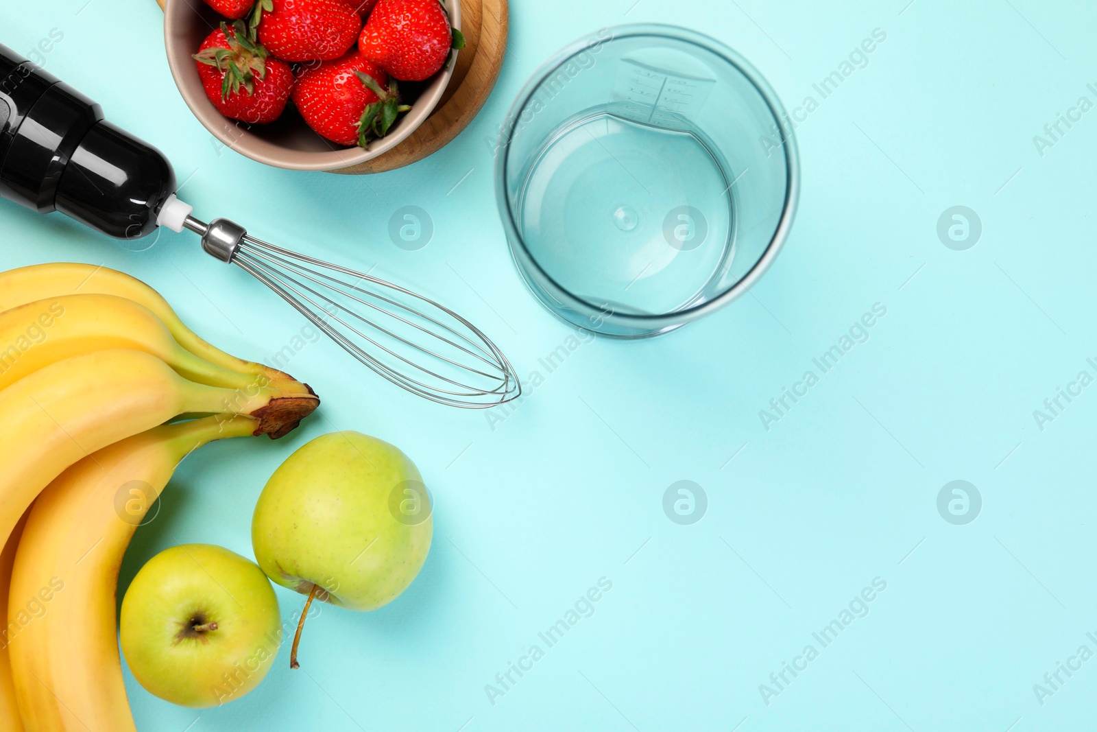 Photo of Hand blender kit and fresh fruits on light blue background, flat lay. Space for text