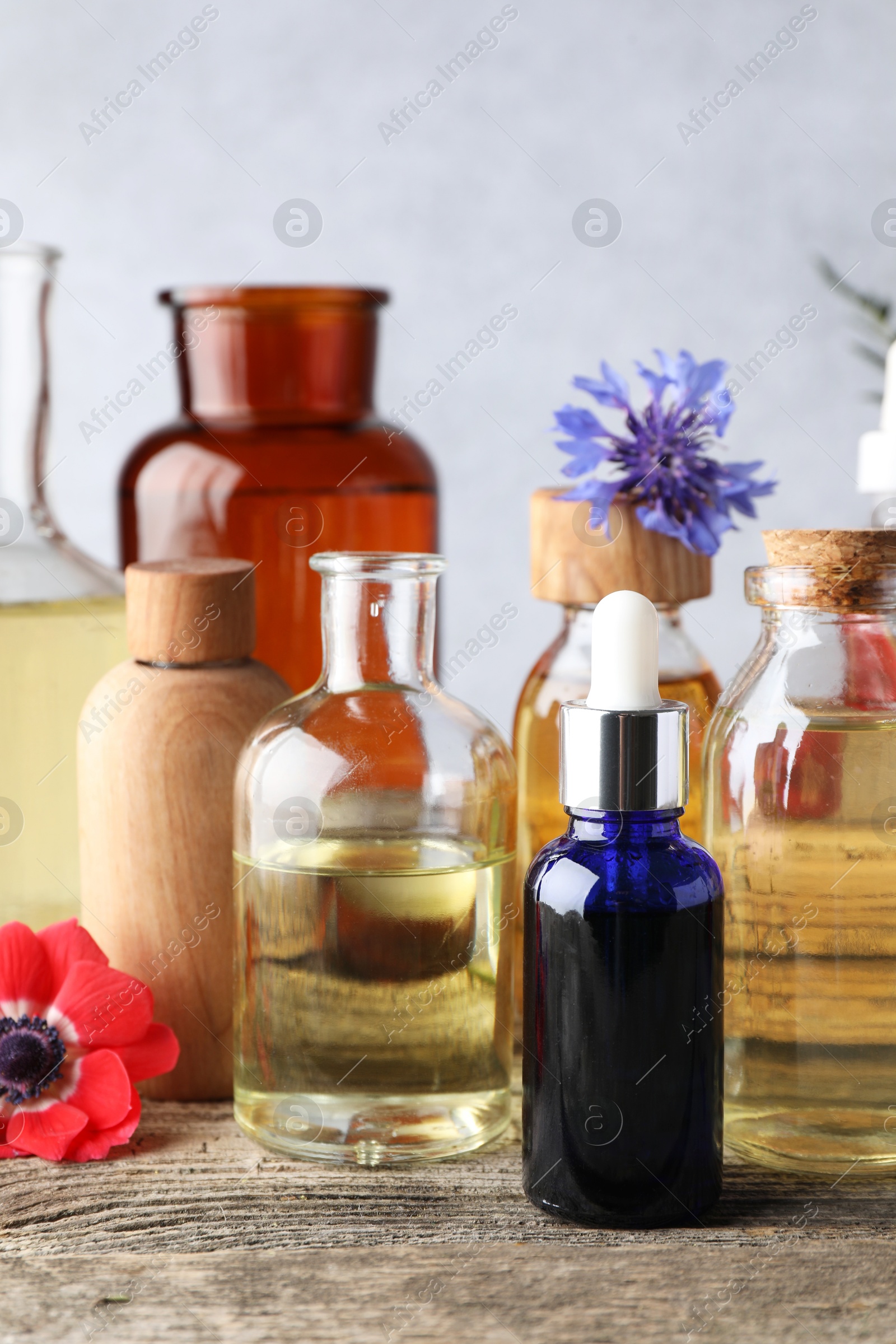 Photo of Aromatherapy. Different essential oils and flowers on wooden table