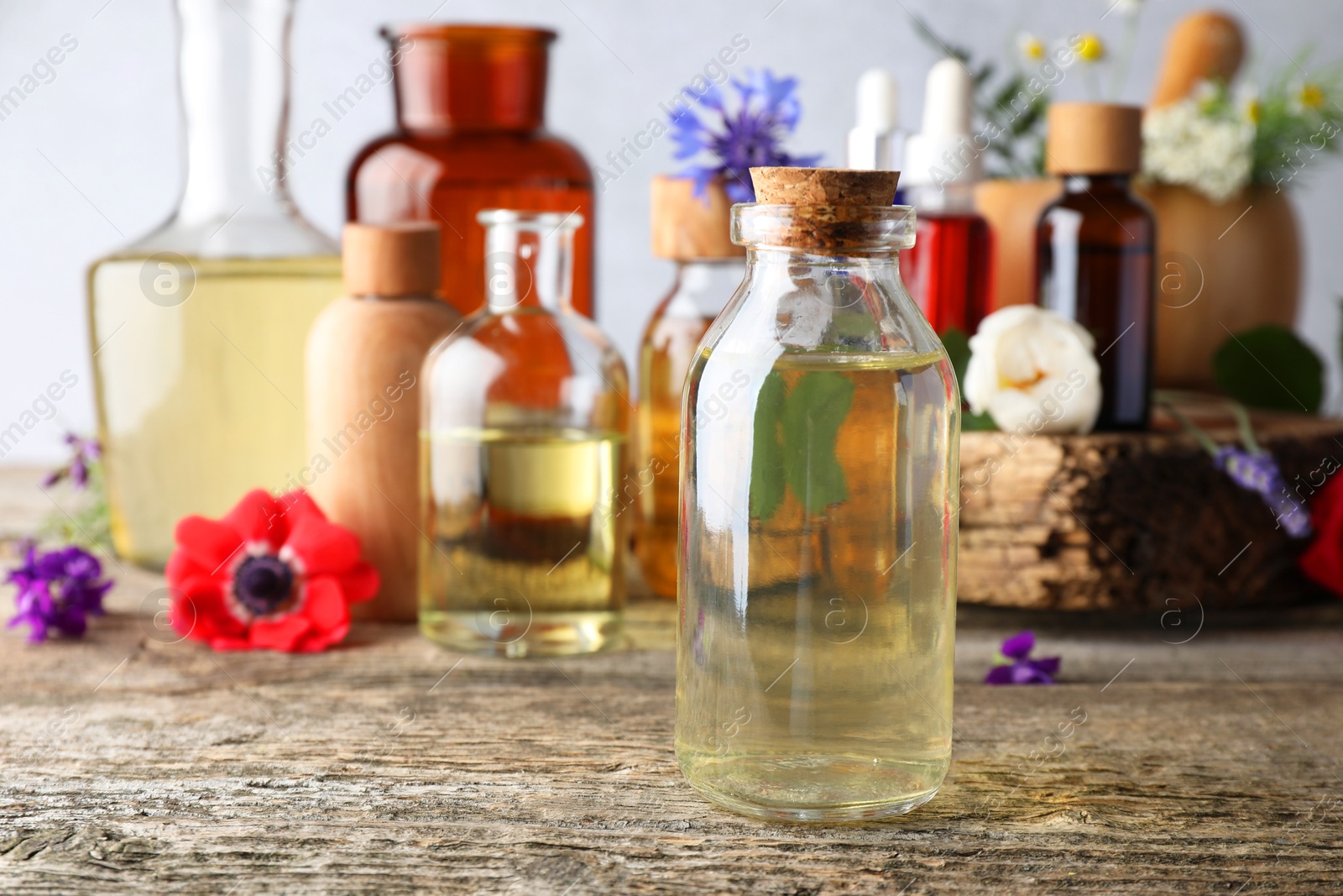 Photo of Aromatherapy. Different essential oils and flowers on wooden table