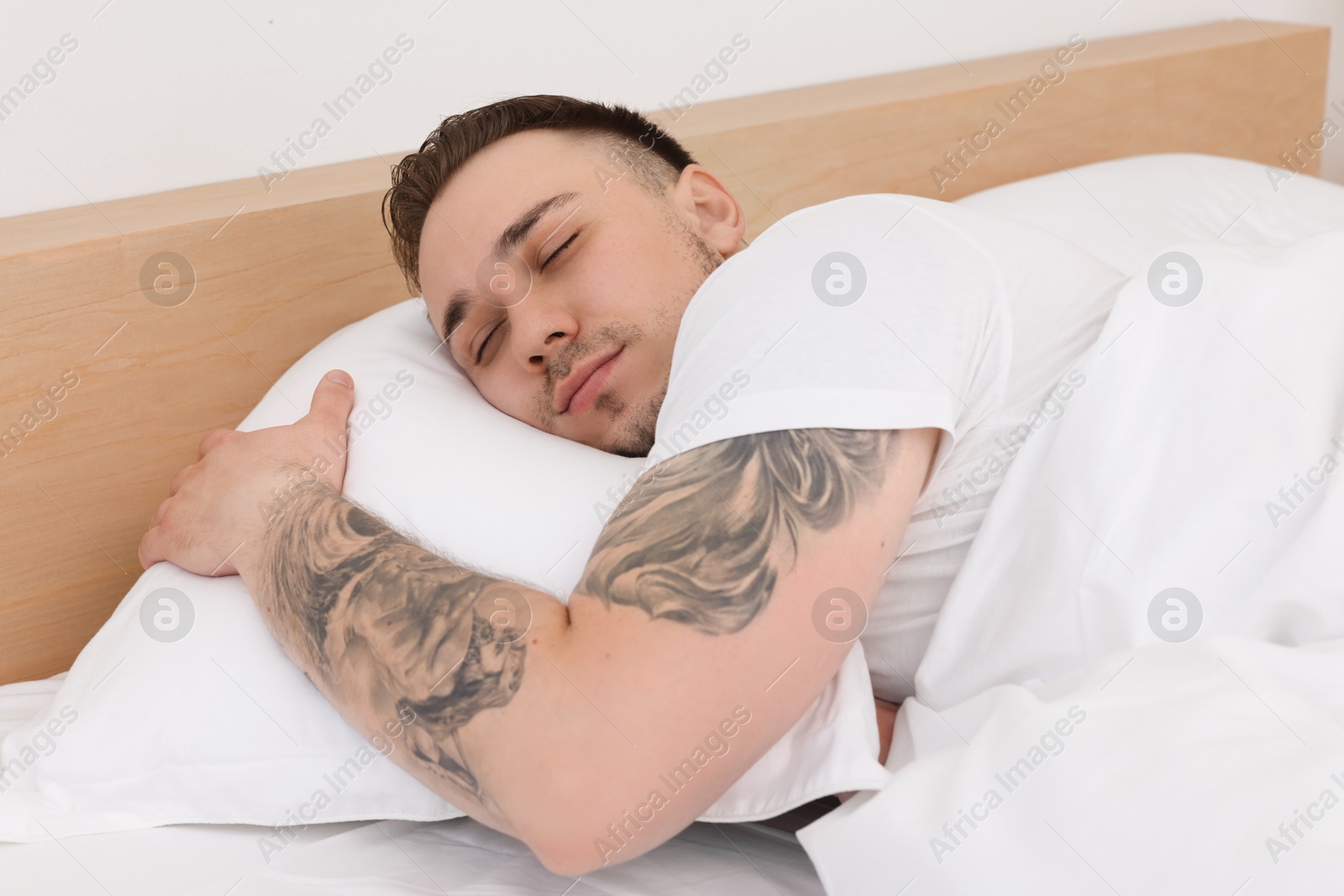 Photo of Bedtime. Handsome man sleeping in bed indoors