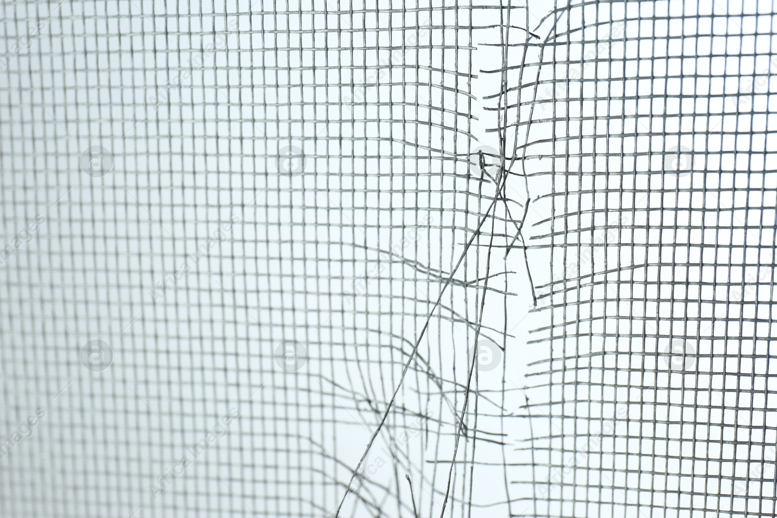 Photo of Torn window screen against white background, closeup