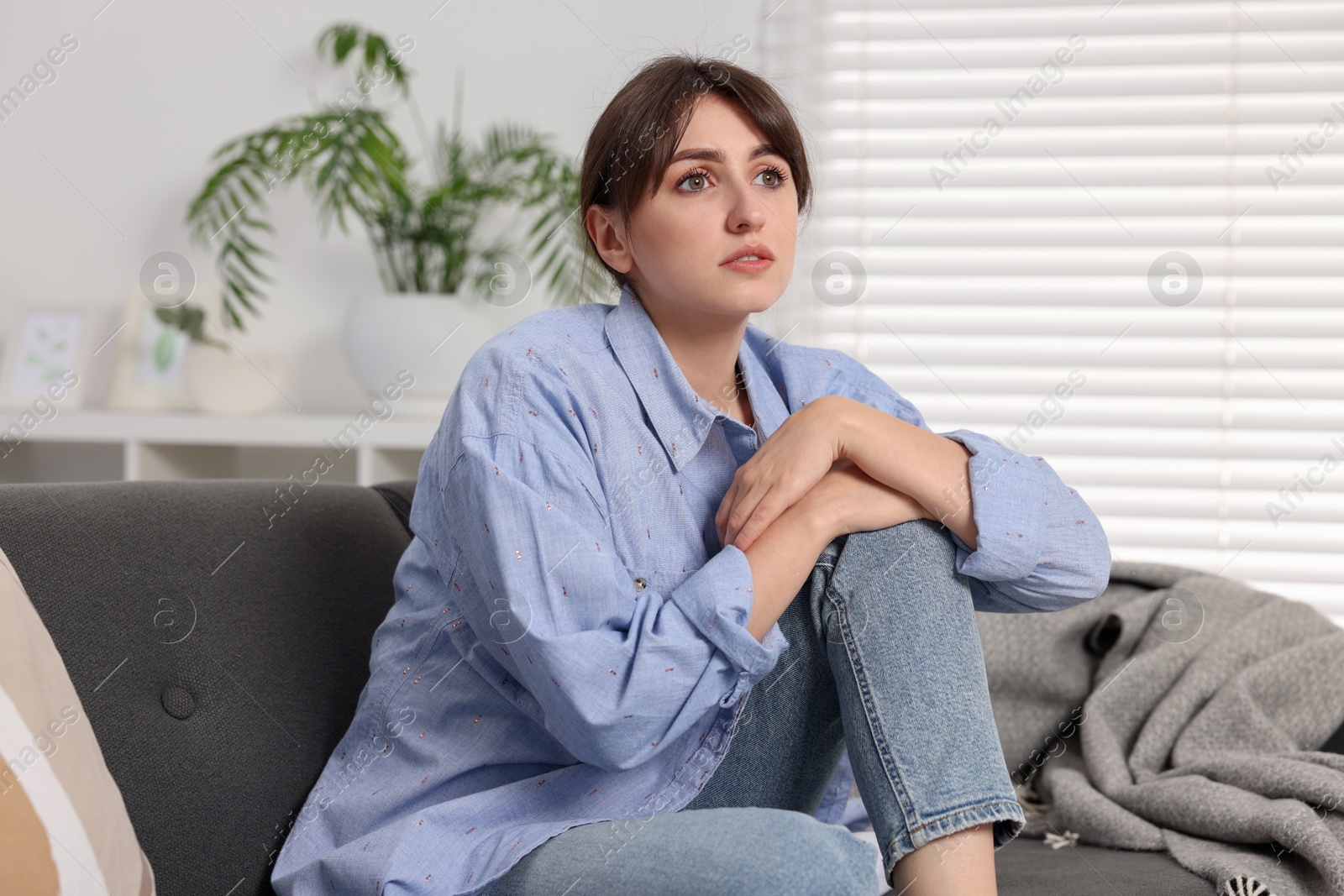 Photo of Loneliness concept. Sad woman sitting on sofa at home