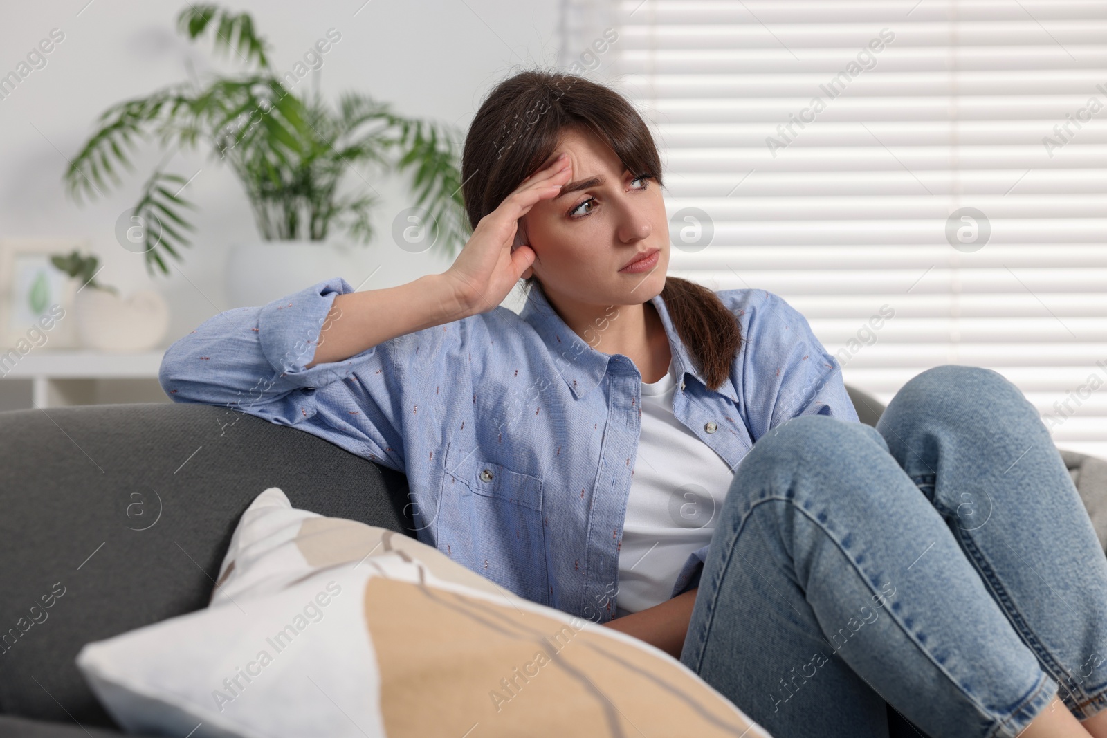 Photo of Loneliness concept. Sad woman sitting on sofa at home