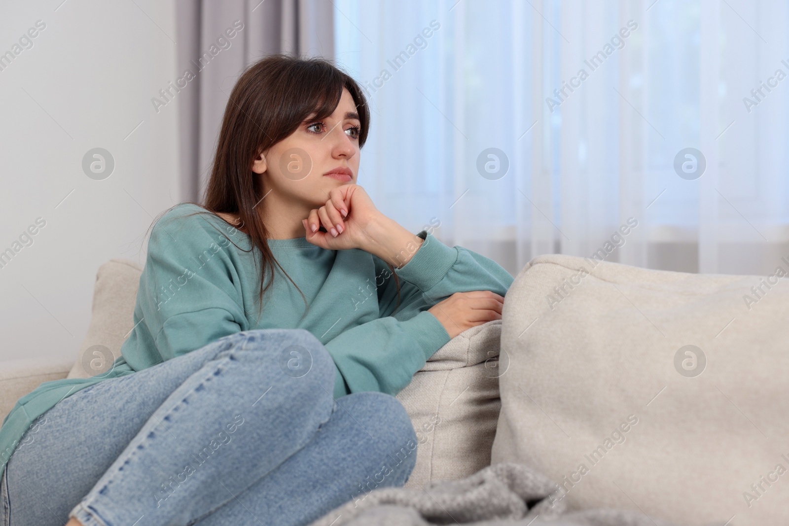 Photo of Loneliness concept. Sad woman sitting on sofa at home