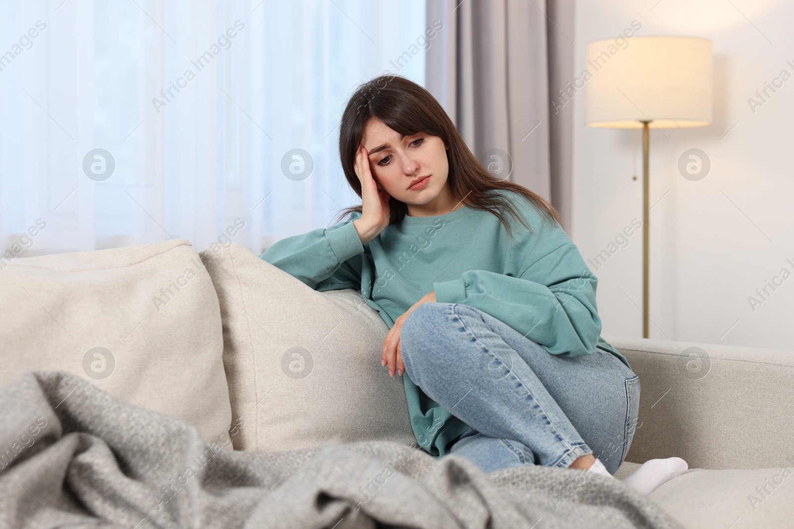 Photo of Loneliness concept. Sad woman sitting on sofa at home