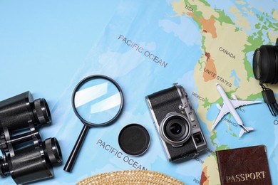 Travel blogger. Flat lay composition with vintage camera and map on light blue background