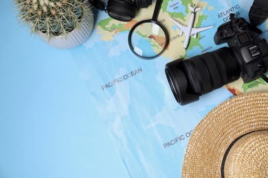 Travel blogger. Flat lay composition with camera and map on light blue background