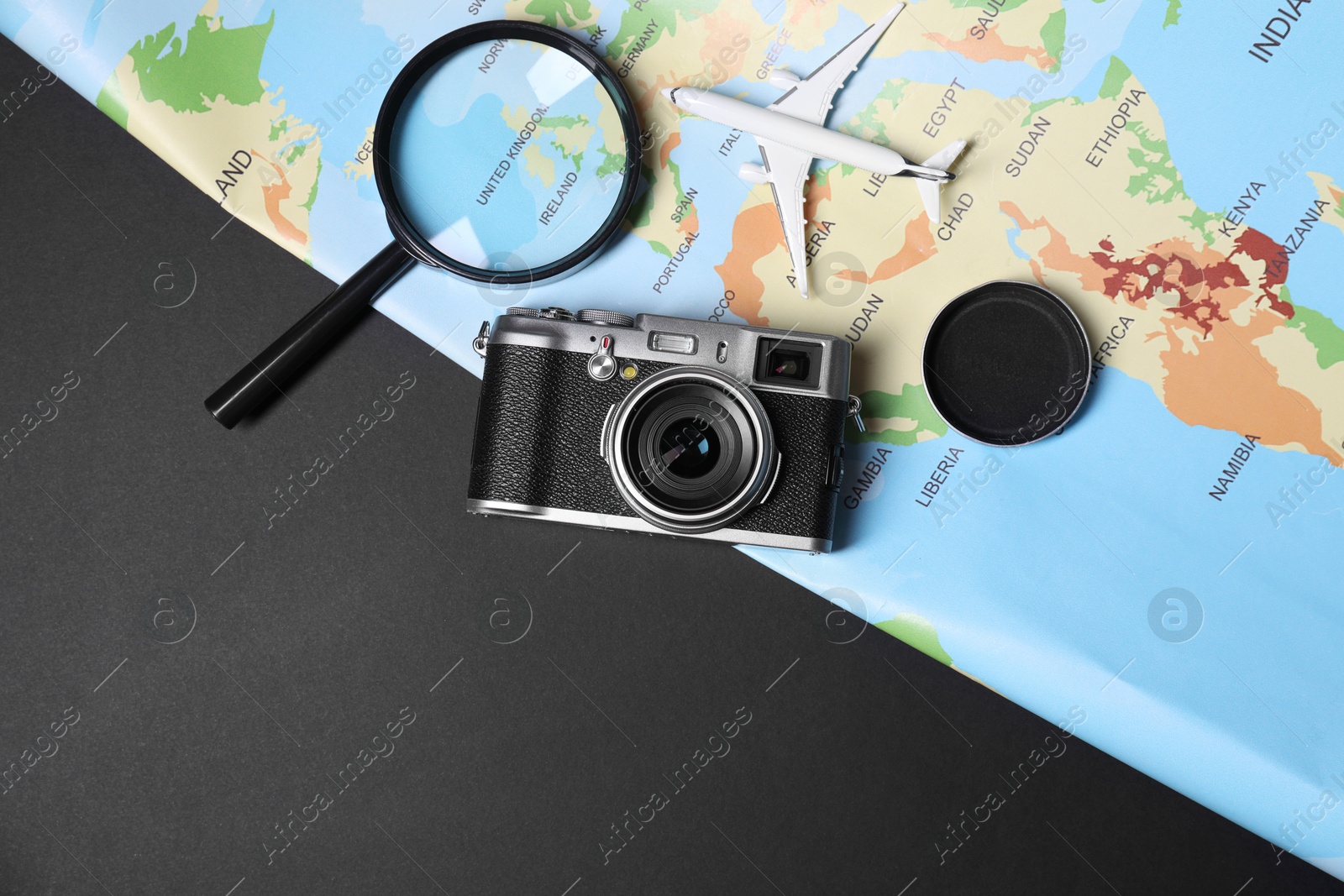 Photo of Travel blogger. Flat lay composition with vintage camera and map on black background