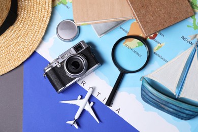 Travel blogger. Flat lay composition with vintage camera and magnifying glass on color background