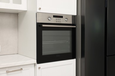 Photo of New electric oven in kitchen. Cooking appliance