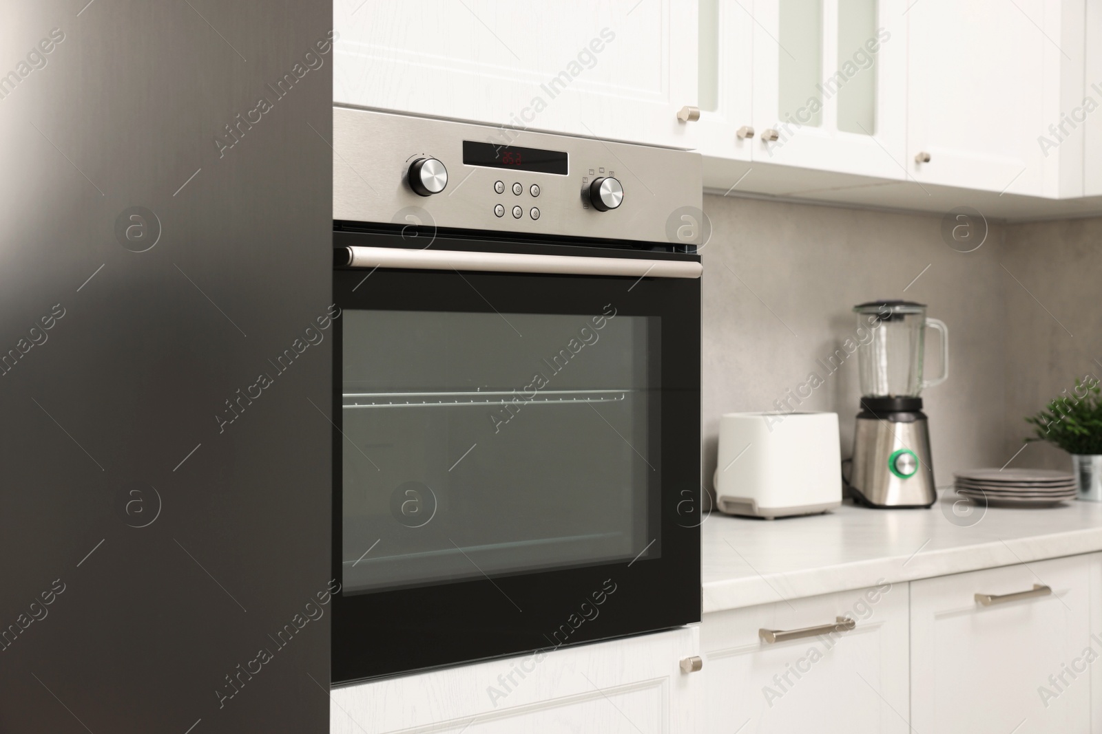 Photo of New electric oven in kitchen. Cooking appliance