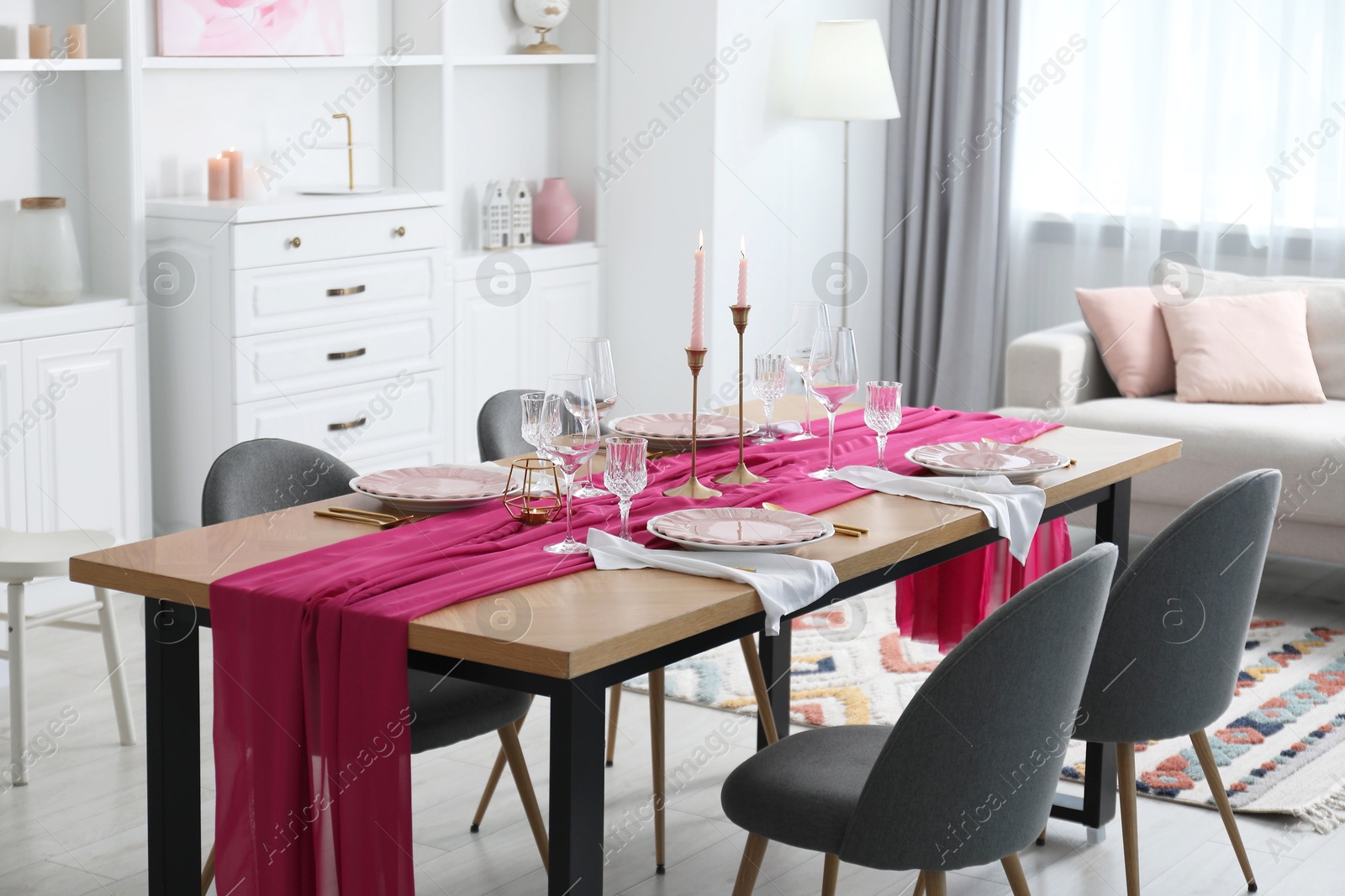 Photo of Beautiful table setting with pink accent and chairs in dining room