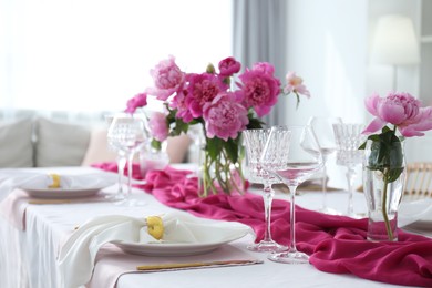 Beautiful table setting with pink peonies in dining room