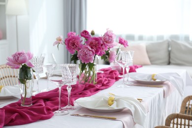 Photo of Beautiful table setting with pink peonies in dining room