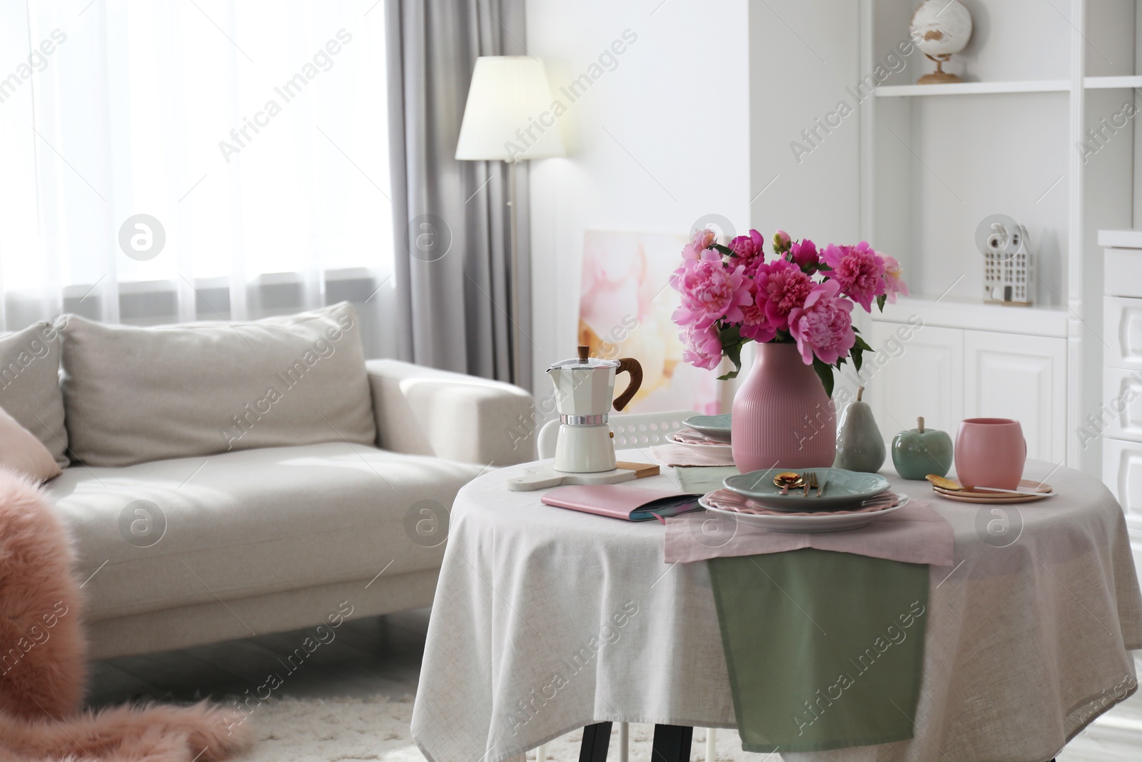 Photo of Beautiful table setting with pink peonies in living room