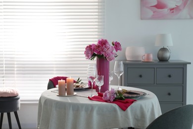 Photo of Beautiful table setting with pink peonies and burning candles