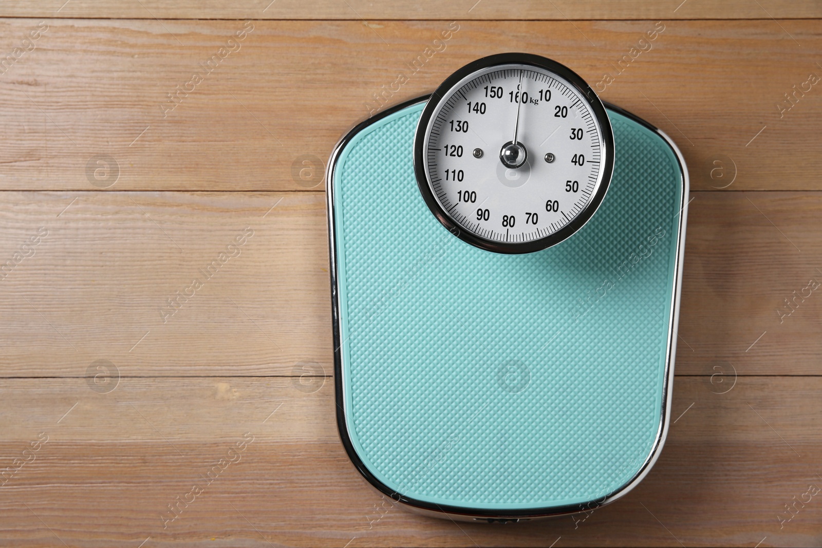 Photo of One bathroom scale on wooden floor, top view. Space for text