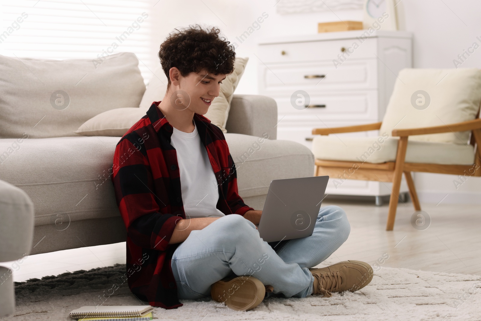 Photo of Teenager working with laptop at home. Remote job