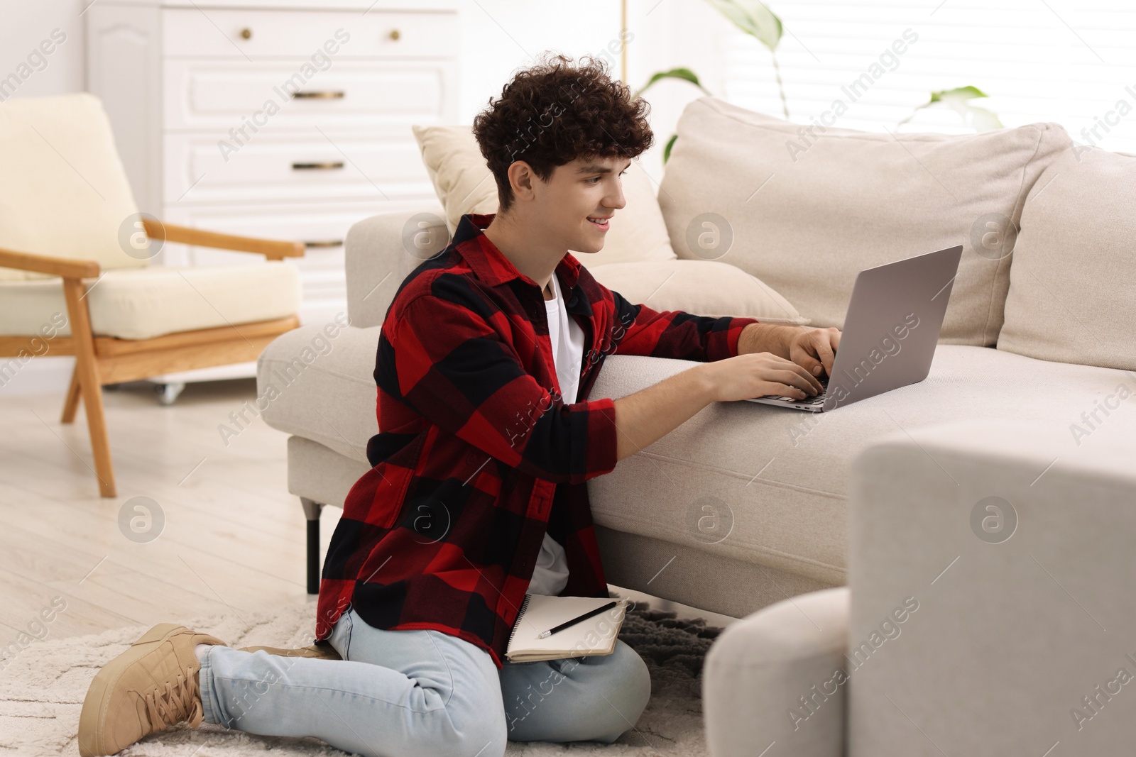 Photo of Teenager working with laptop at home. Remote job