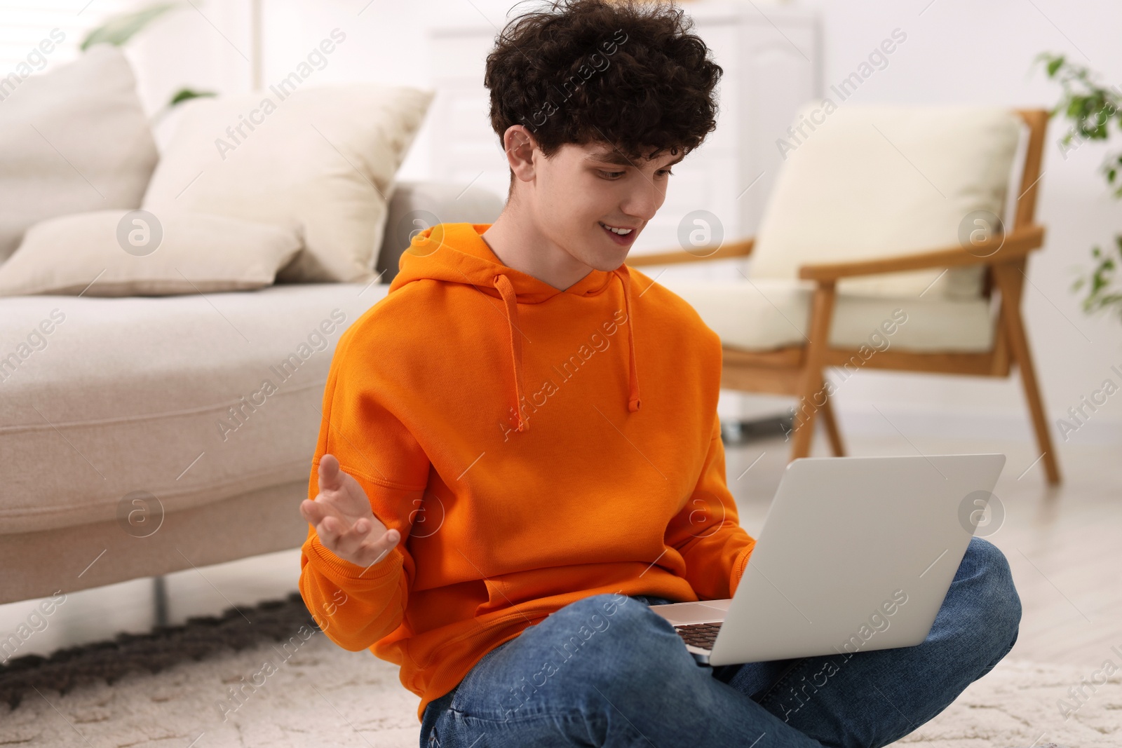 Photo of Teenager having video chat via laptop at home. Remote work