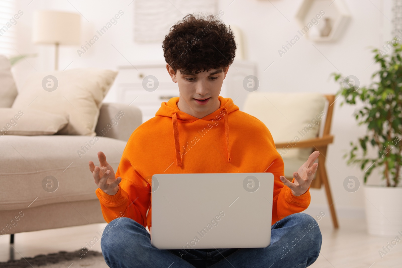 Photo of Teenager having video chat via laptop at home. Remote work