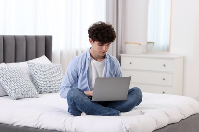 Photo of Teenager working with laptop on bed at home. Remote job