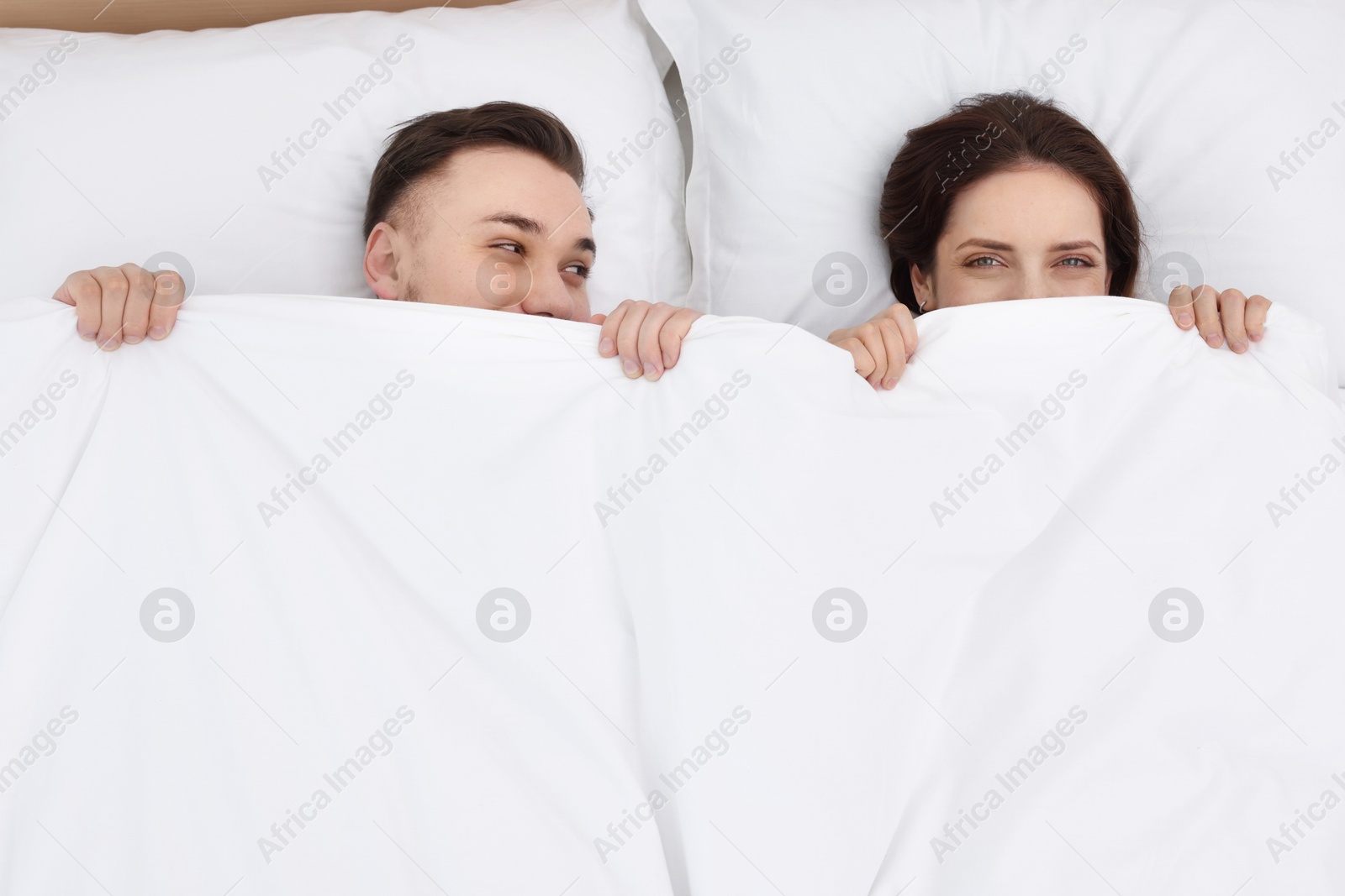 Photo of Lovely couple lying in bed at home, above view