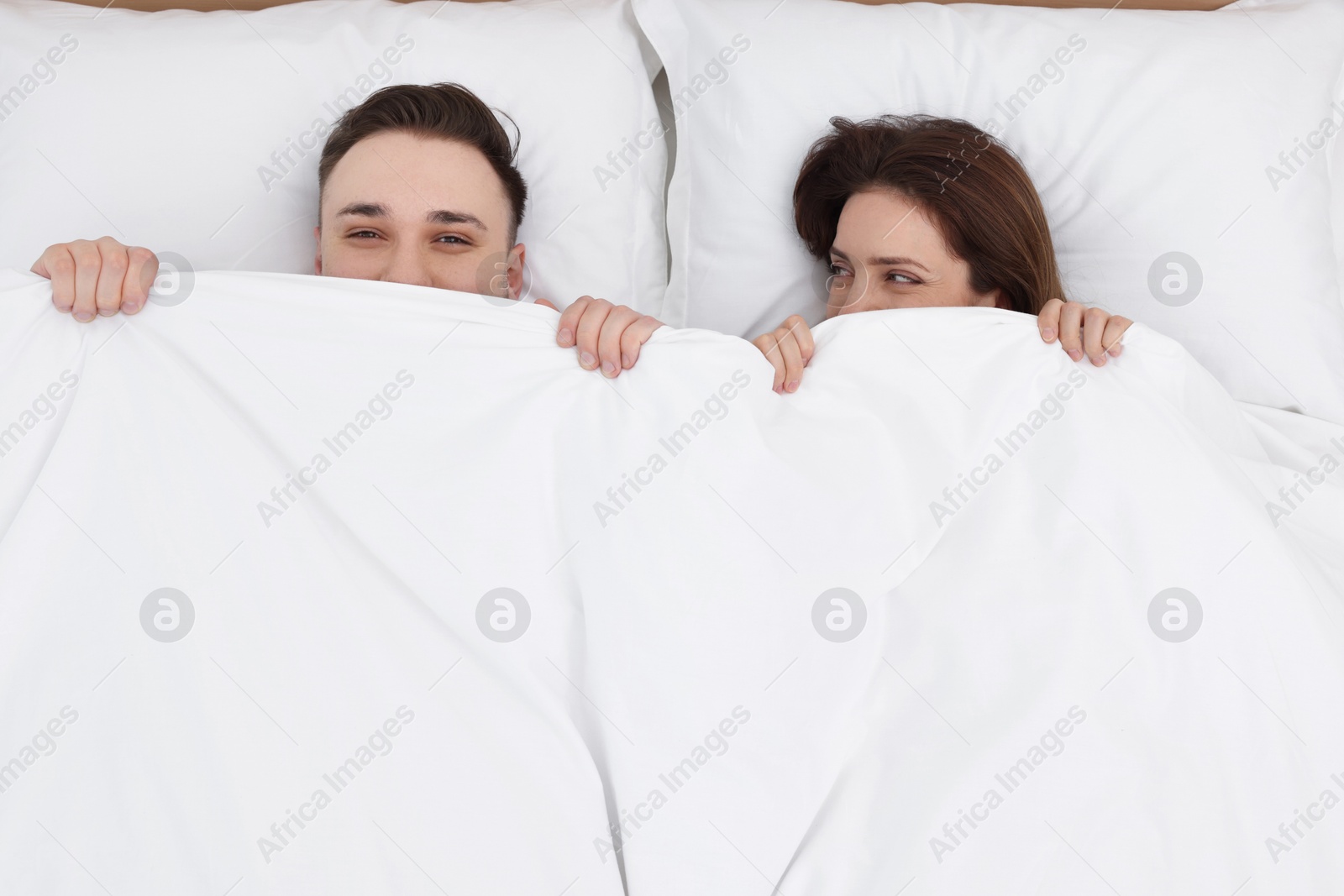 Photo of Lovely couple lying in bed at home, above view