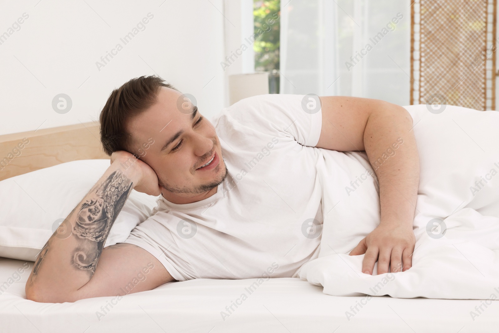 Photo of Bedtime. Handsome man lying in bed indoors