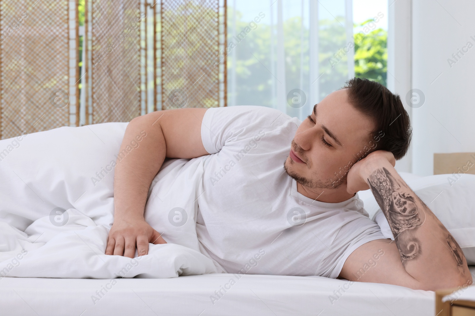 Photo of Bedtime. Handsome man lying in bed indoors