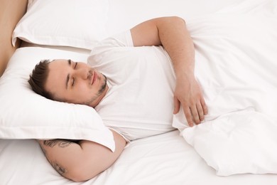 Photo of Bedtime. Handsome man sleeping in bed indoors