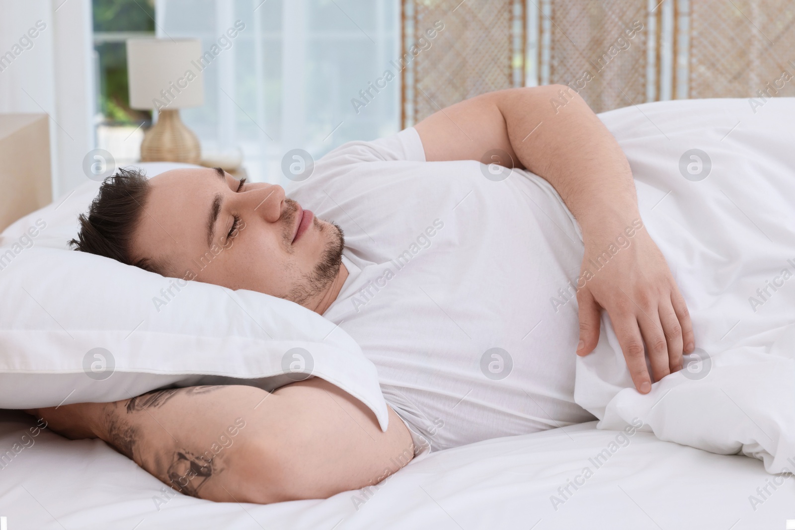 Photo of Bedtime. Handsome man sleeping in bed indoors