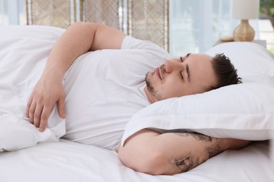 Photo of Bedtime. Handsome man sleeping in bed indoors