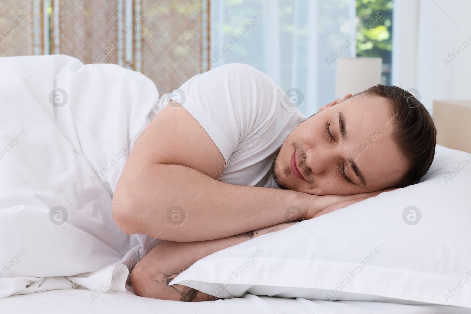 Photo of Bedtime. Handsome man sleeping in bed indoors