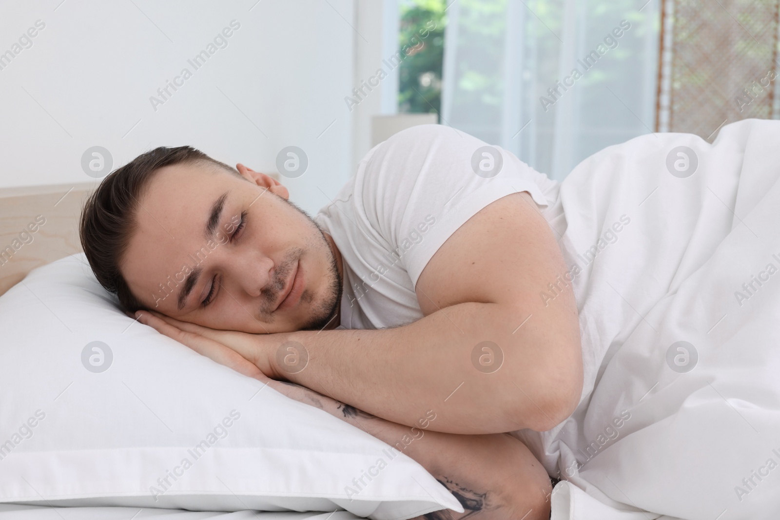 Photo of Bedtime. Handsome man sleeping in bed indoors