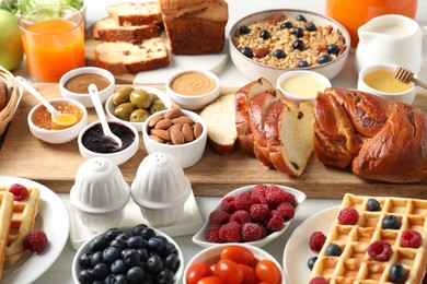 Photo of Different meals served for breakfast on white table