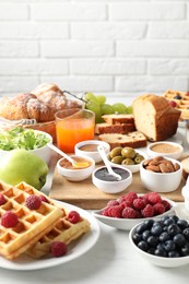 Different meals served for breakfast on white table