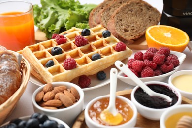 Photo of Different meals served for breakfast on white table, closeup. Buffet menu