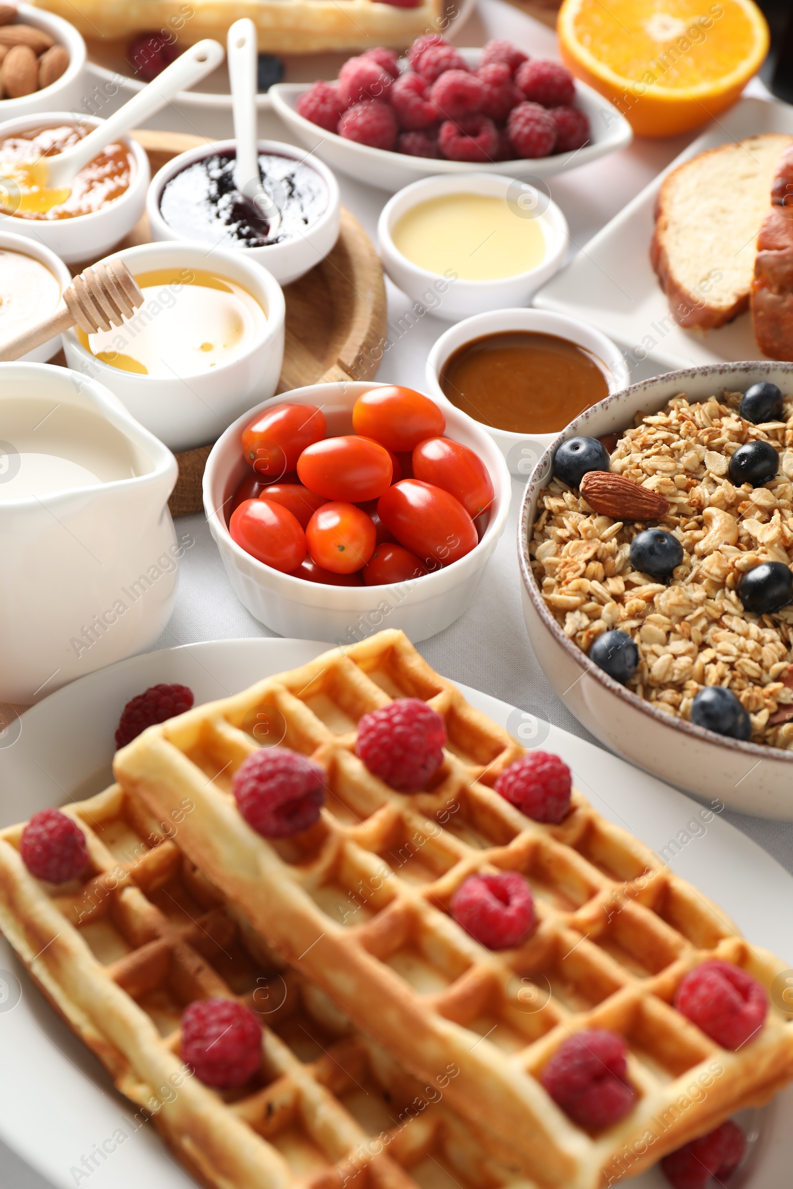 Photo of Different meals served for breakfast on white table, closeup. Buffet menu