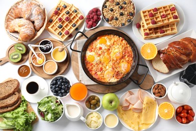 Different meals served for breakfast on white table, flat lay