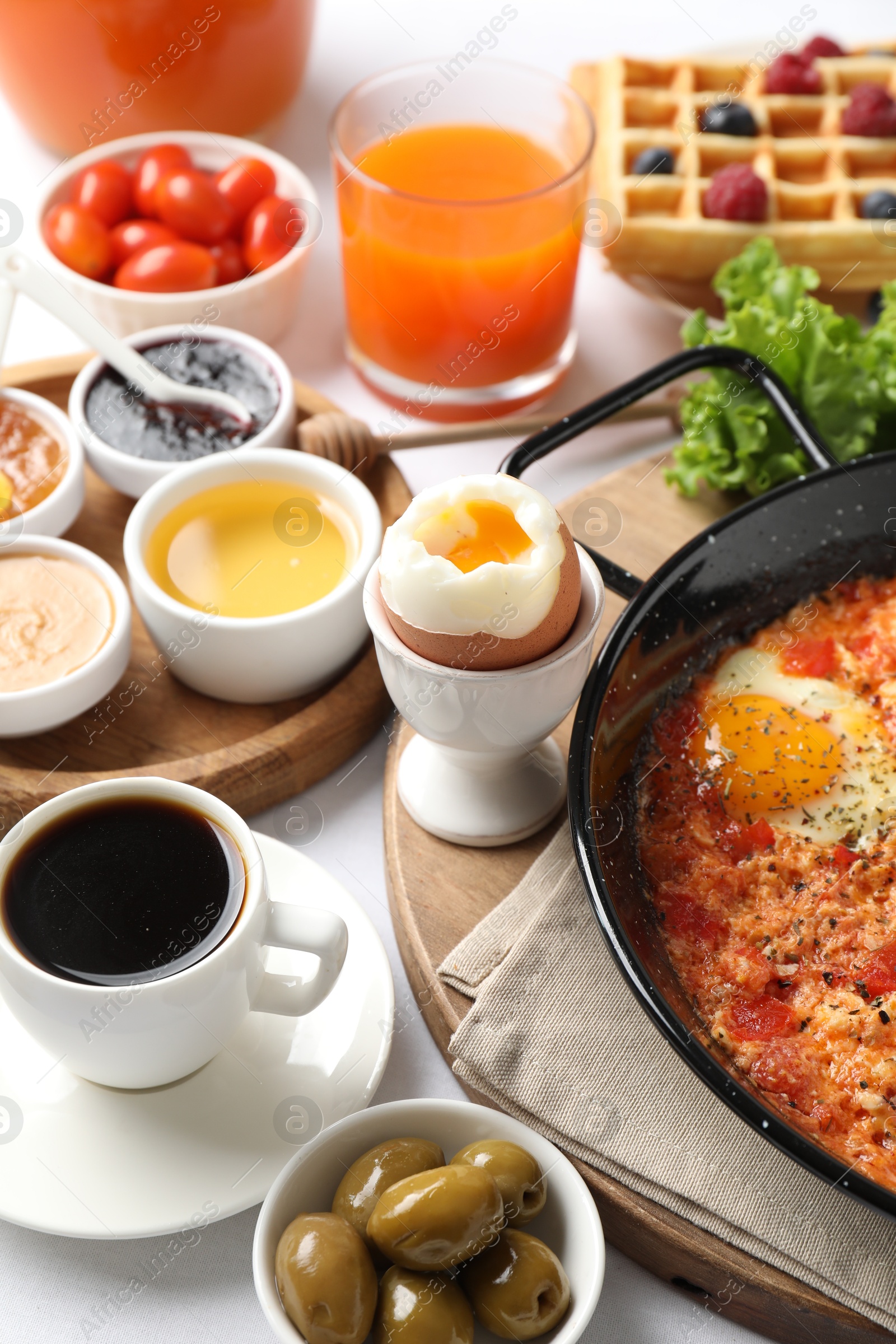 Photo of Cup of coffee and different meals served for breakfast on white table, closeup