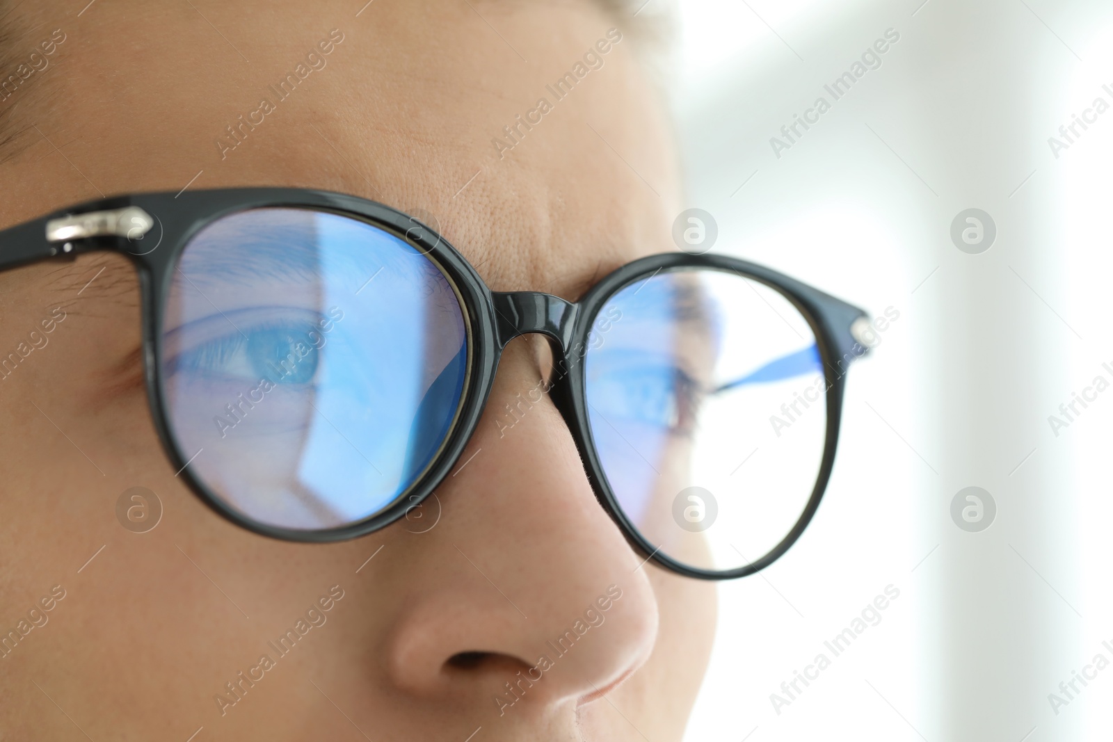 Photo of Vision correction. Man wearing glasses on blurred background, closeup