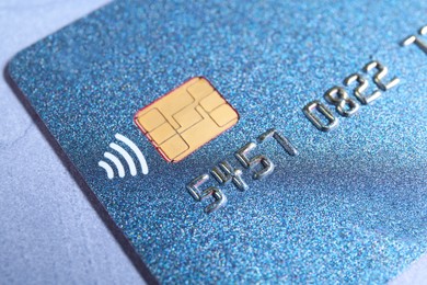 Photo of One credit card on grey table, closeup