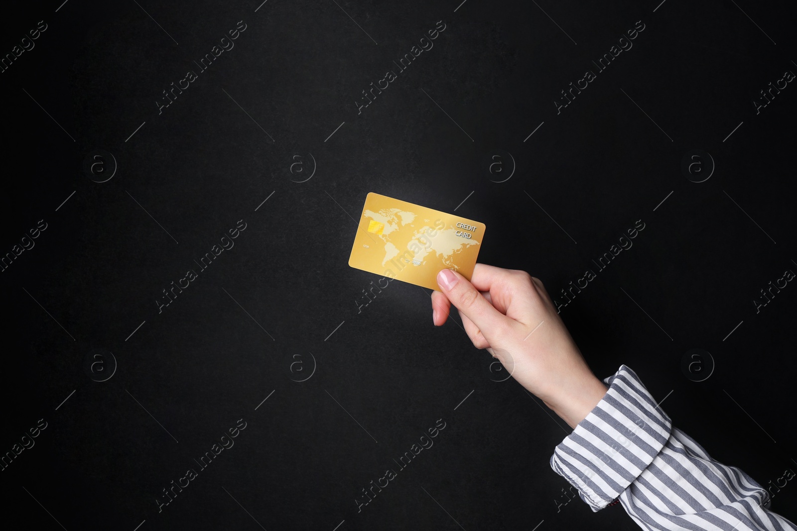 Photo of Woman holding credit card on black background, closeup