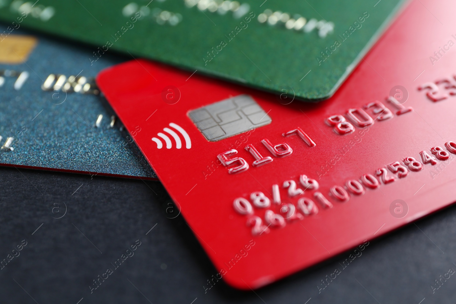 Photo of Different credit cards on black background, closeup