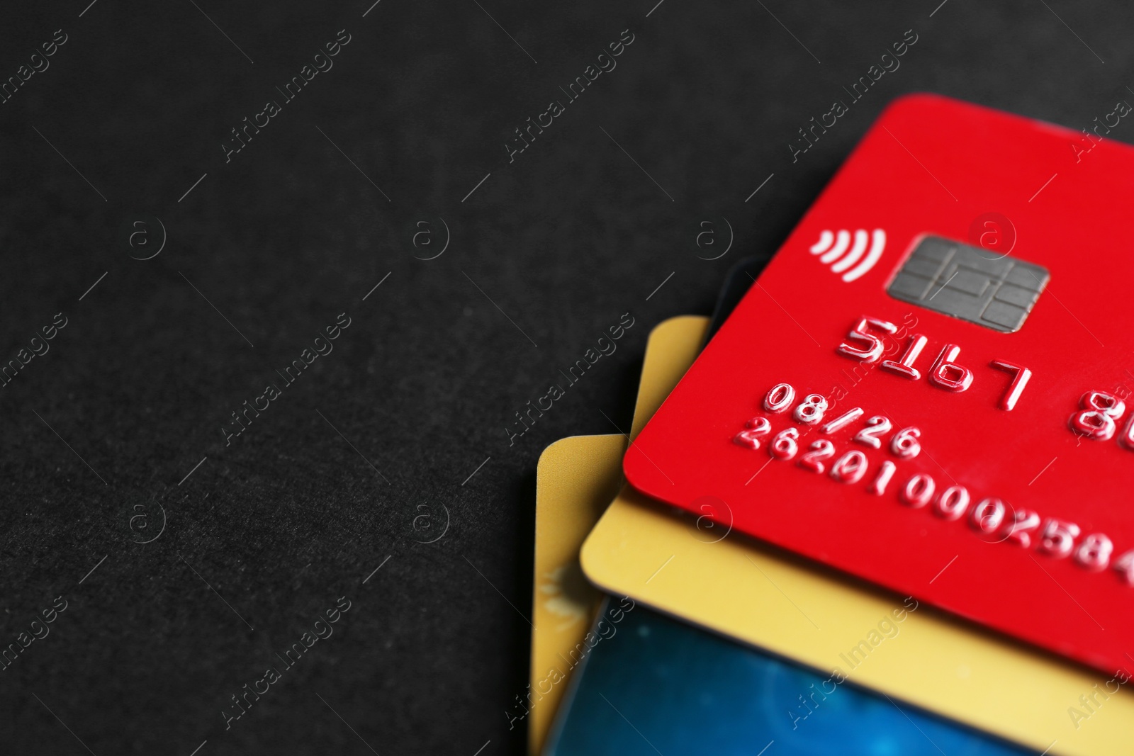 Photo of Different credit cards on black background, closeup. Space for text